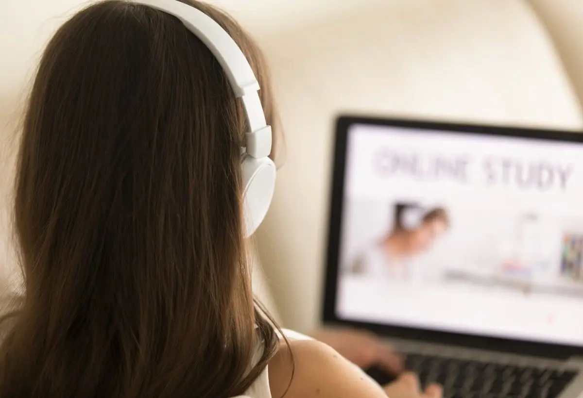 Frau mit Kopfhörern beim Online-Kurs am Laptop